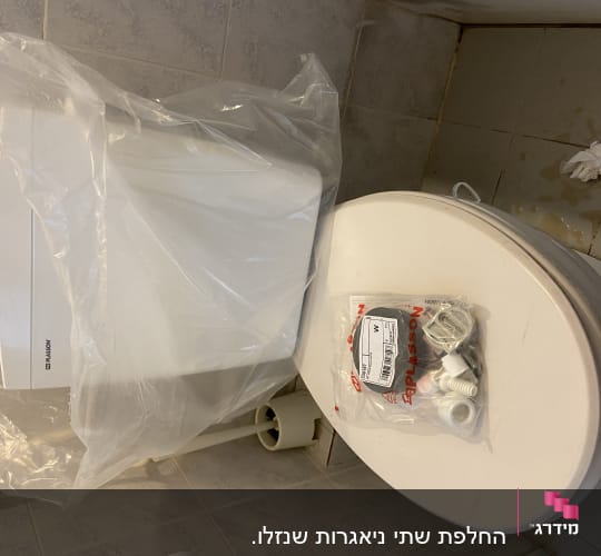 אסלה עם חלקי אינסטלציה על המכסה